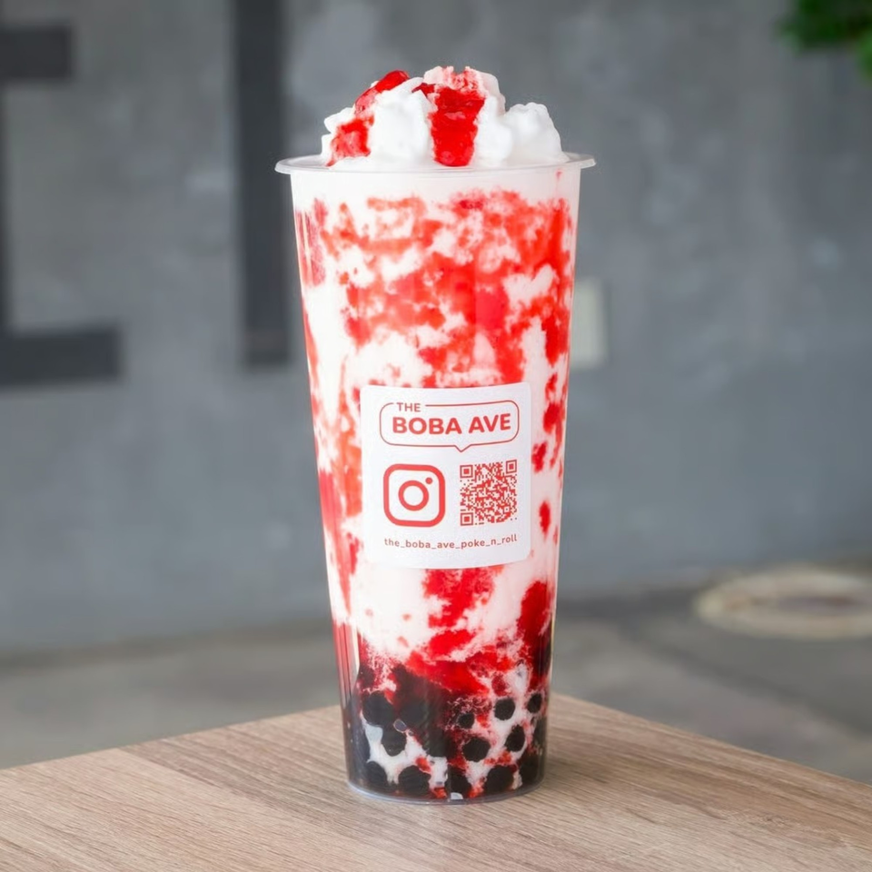 A strawberry boba drink from The Boba Ave, topped with whipped cream and strawberry syrup.