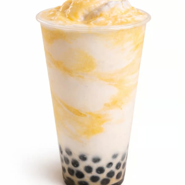 A tall plastic cup of mango boba tea with white and yellow swirls and black tapioca pearls.